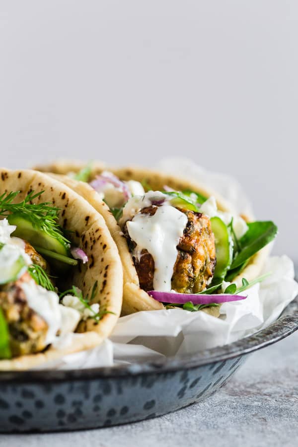 Greek Chicken Meatball Gyros topped with tzatziki.