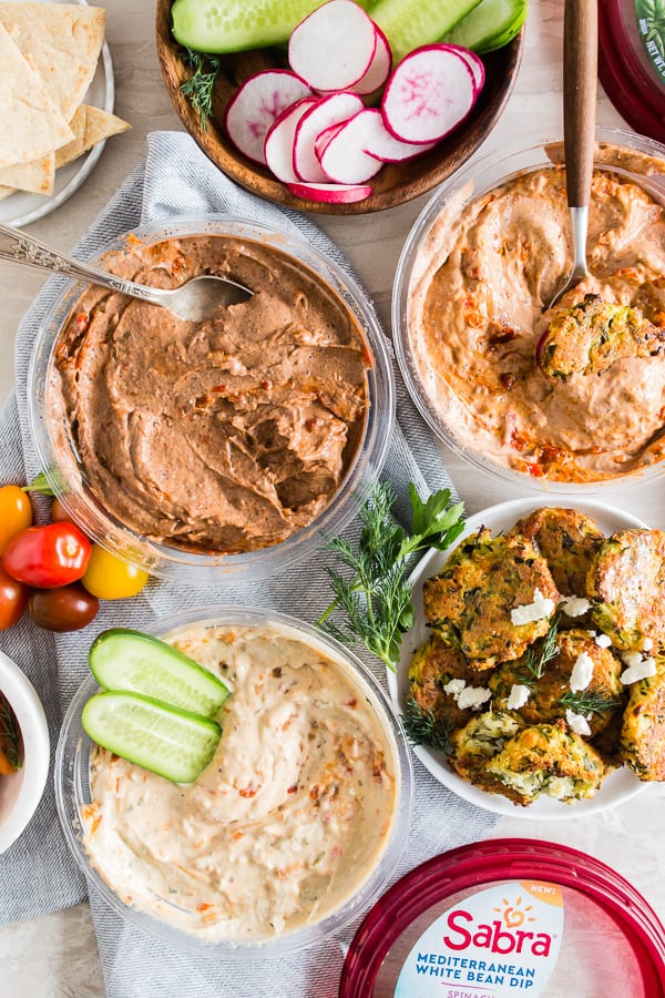 Greek Zucchini Fritters on a table with other dips.