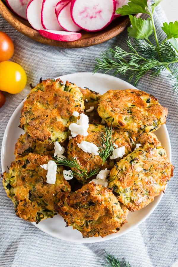 Greek Zucchini Fritters topped with a sprinkle of fresh dill.