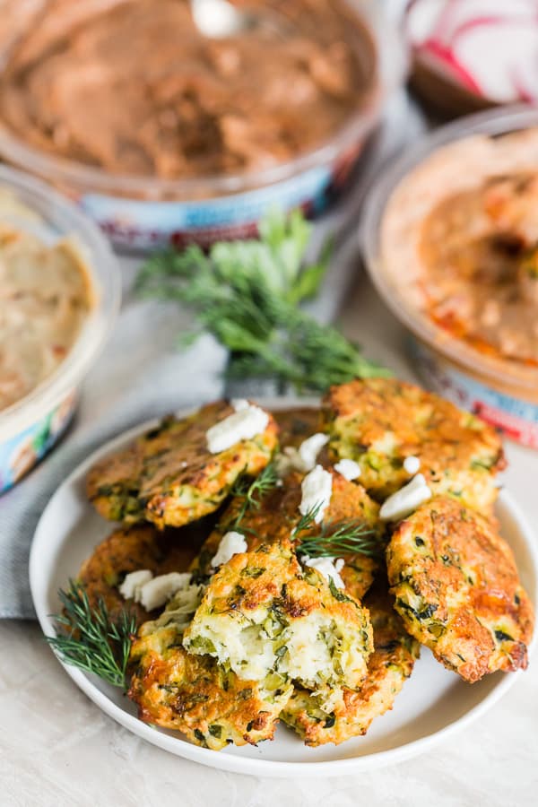 Greek Zucchini Fritters on a plate topped with feta.