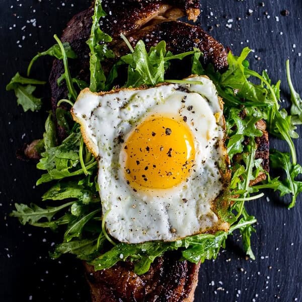 This fried egg topped steak is your breakfast or dinner of your dreams. Deliciously seasoned steak grilled and then topped with a lightly dressed arugula salad and a super crispy around the edges fried egg. This is the type of dish you'll devour and dream about! 