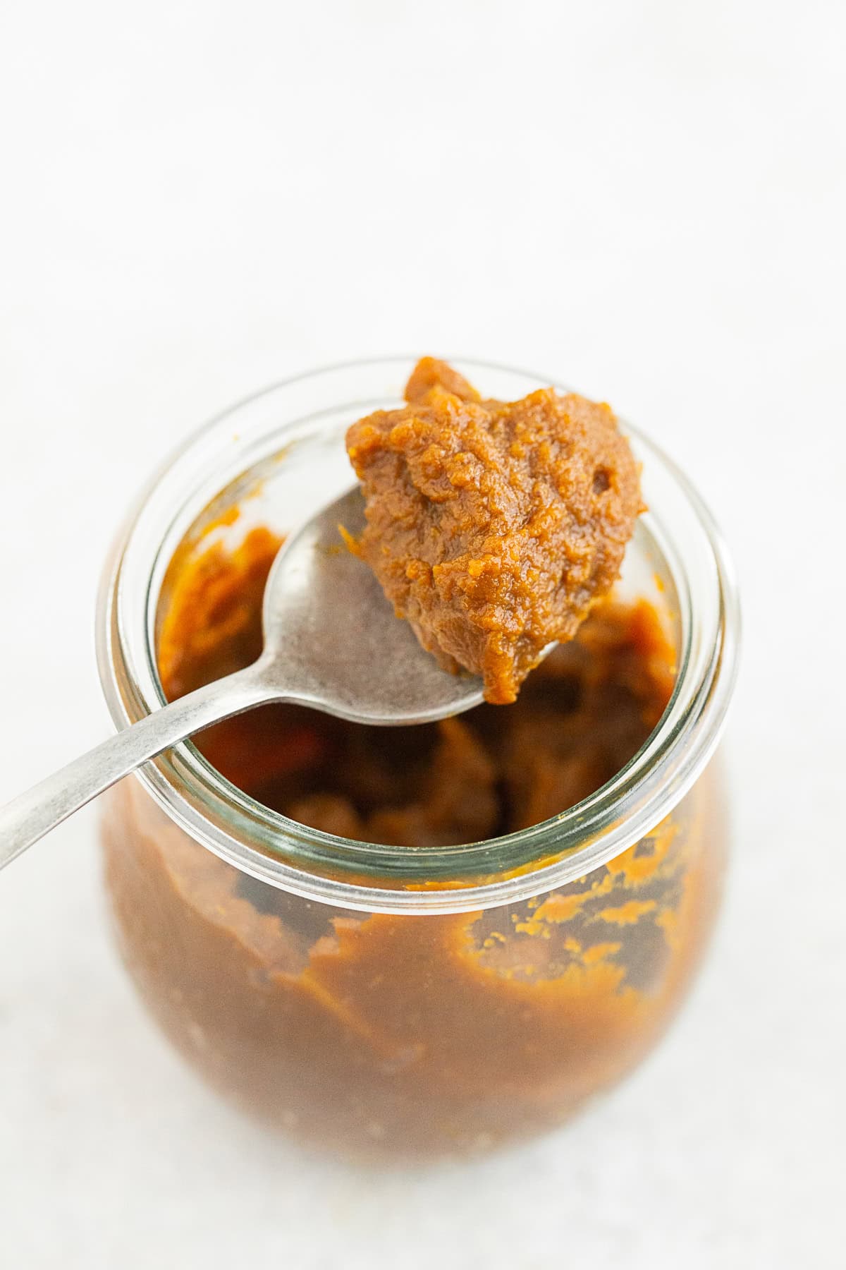 apple butter in a jar with a spoon. 
