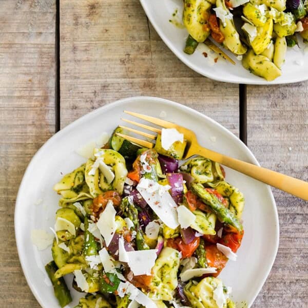 This roasted vegetables tortellini salad is the perfect way to use up all those summer vegetables. Perfectly roasted vegetables mixed with cheese tortellini and tangy basil vinaigrette mixed together and sprinkled with shaved Parmesan cheese. You'll love this easy salad! 