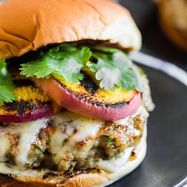 This cheesy grilled peach jalapeno turkey burger is the perfect combination of sweet and spicy. Fresh summer peaches grilled to bring out their sweetness and paired with a herb, cheese and jalapeno packed turkey burger and topped with sharp cheddar cheese and a sprinkling of cilantro. If youโre a fan of sweet and heat this burger is for you!