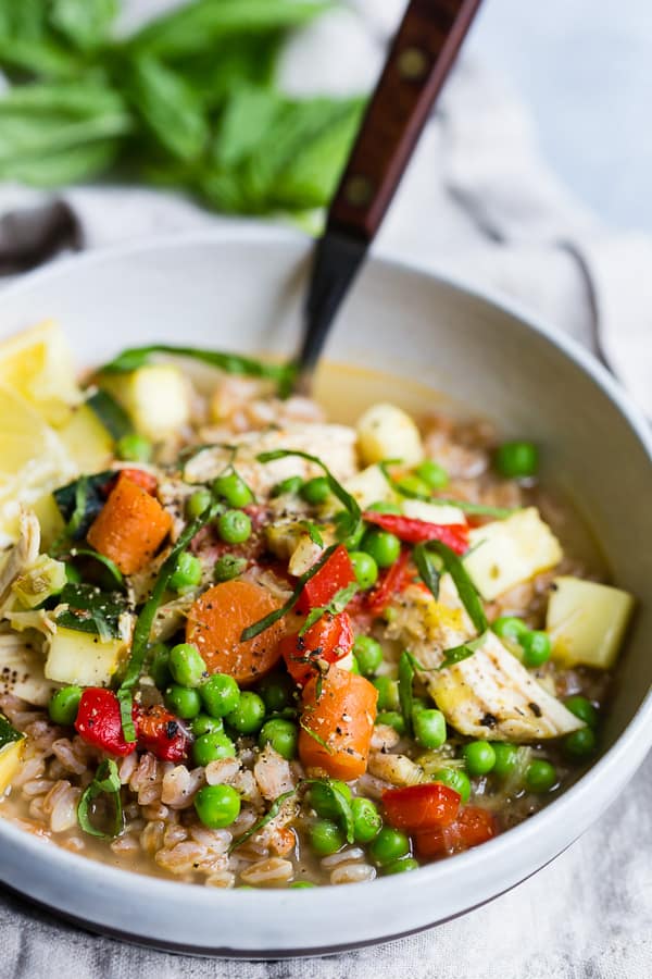 Lemon Chicken Vegetable Farro Soup served with fresh basil.