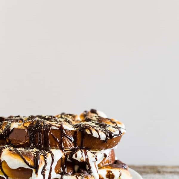 This s'mores French toast is LOADED with bigtime marshmallow flavor and the perfect special occasion sweet breakfast or over-the-top dessert. Thick sliced vanilla bean challah bread French toast topped with toasted marshmallows, drizzled with chocolate sauce and sprinkled with graham cracker crumbs.