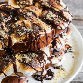 This s'mores French toast is LOADED with bigtime marshmallow flavor and is the perfect special occasion sweet breakfast or over-the-top dessert. Thick sliced vanilla bean challah bread French toast topped with toasted marshmallows, drizzled with chocolate sauce and sprinkled with graham cracker crumbs. What's not to love?