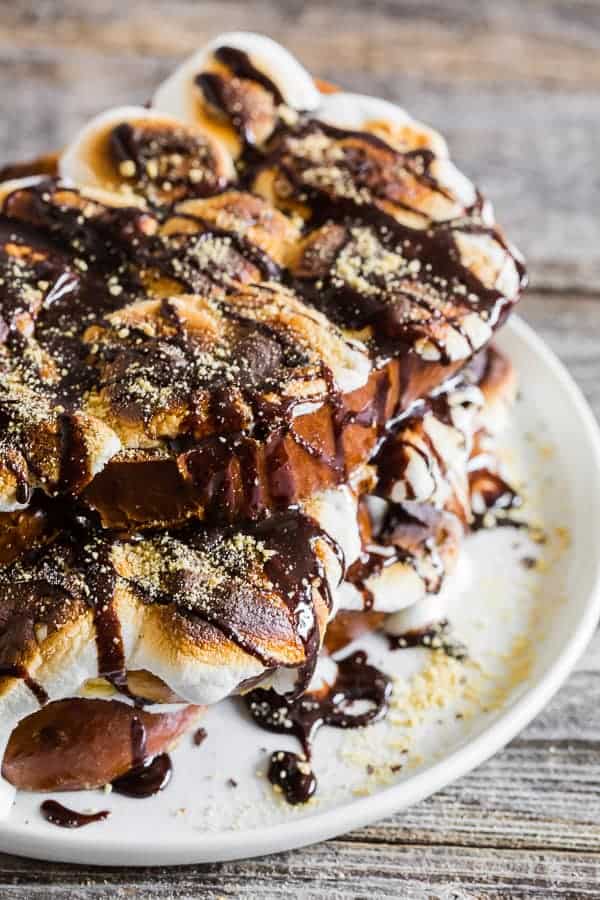 s'mores french toast served on a white plate with chocolate sauce.