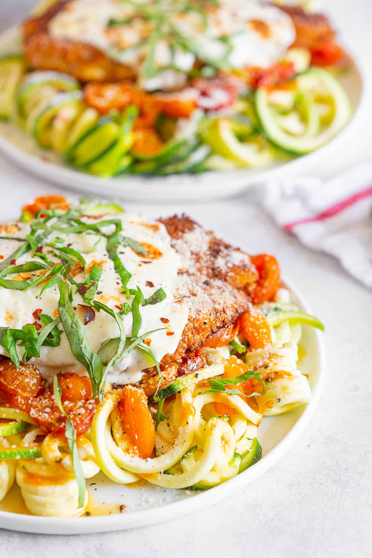 Summer Chicken Parmesan with Zoodles served with fresh basil.