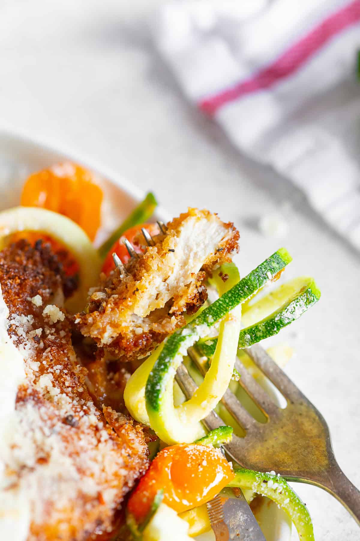 Summer Chicken Parmesan with Zoodles on a plate with a fork.