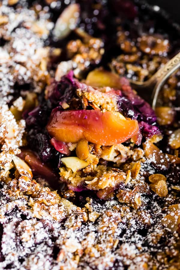 up close shot of a peach inside a blueberry peach cast iron crisp.