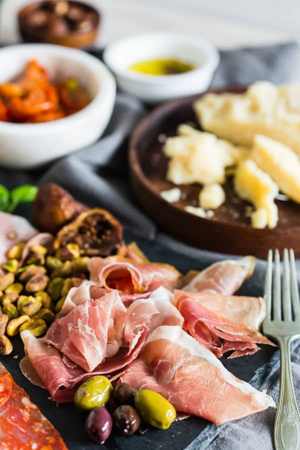 Close-up of charcuterie board meats and olives.