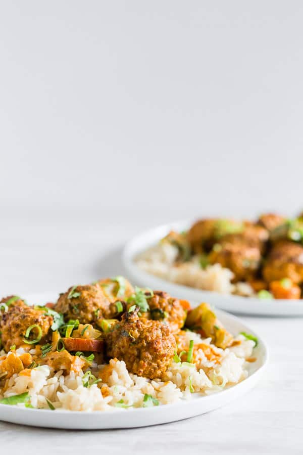 Red Curry Turkey Meatballs on a plate with rice and green onion. 