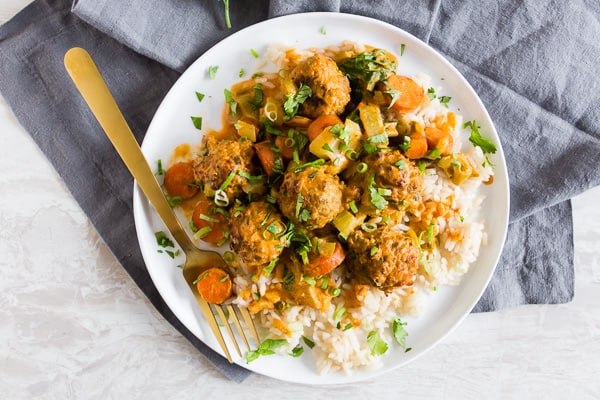 Red Curry Turkey Meatballs on a plate with a fork. 