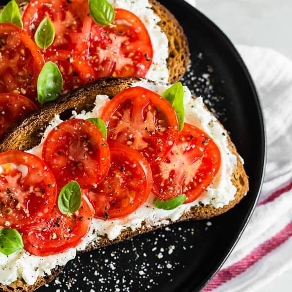 This ricotta tomato toast is my favorite way to start the day. Crunchy toasted whole wheat sourdough spread with creamy ricotta cheese and topped with sun-ripened tomatoes, kosher salt, and black pepper. For an extra boost of flavor add some fresh basil leaves. 