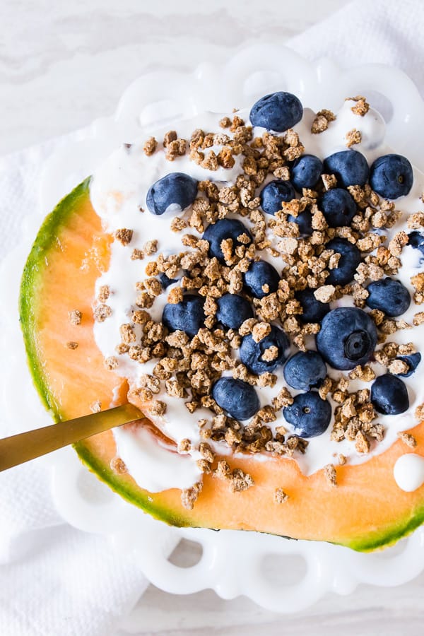 Crunchy Yogurt Cantaloupe Breakfast Bowl served with a spoon. 