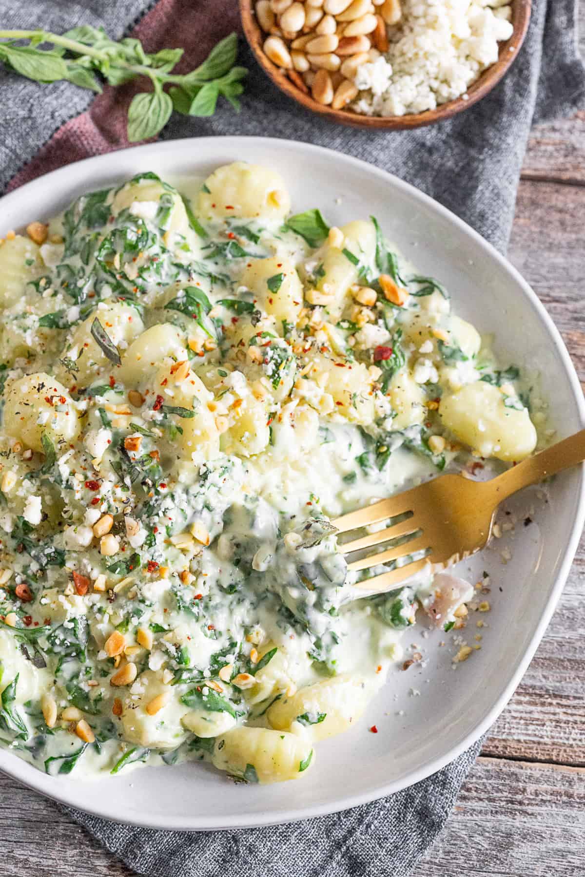 creamy gorgonzola gnocchi on a plate with a fork picking up gnocchi. 