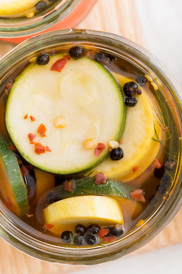 sweet and spicy zucchini pickles in a glass jar with the lid off