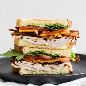 This turkey and cheese BLT sandwich is the perfect back to school sandwich. It combines lightly toasted bread with a homemade garlic basil mayonnaise, sliced turkey, sharp cheddar cheese, crispy bacon, sliced tomato and baby arugula. It's flavorful, easy to make and a step above your everyday bagged lunch sandwich.