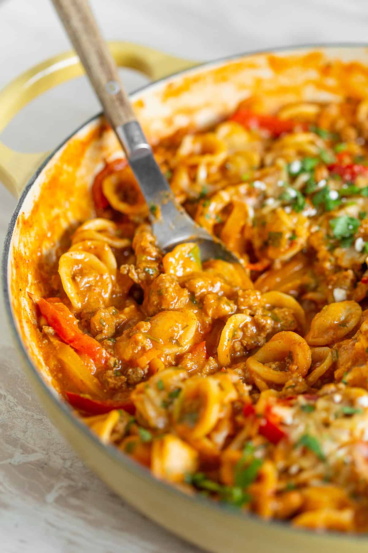 one pot ground chicken fajita pasta with a spoon in a yellow dish