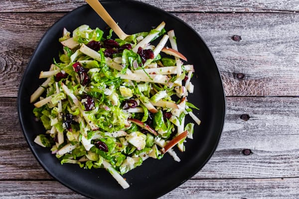 Tangy Brussels Sprout Apple Slaw served with a fork.