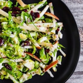 This tangy Brussels sprout apple slaw is a great addition to your fall menu. Crispy shaved Brussels sprout combined with dried cranberries, and apples all tossed in a homemade shallot whole grain mustard vinaigrette. You'll love this simple side dish!