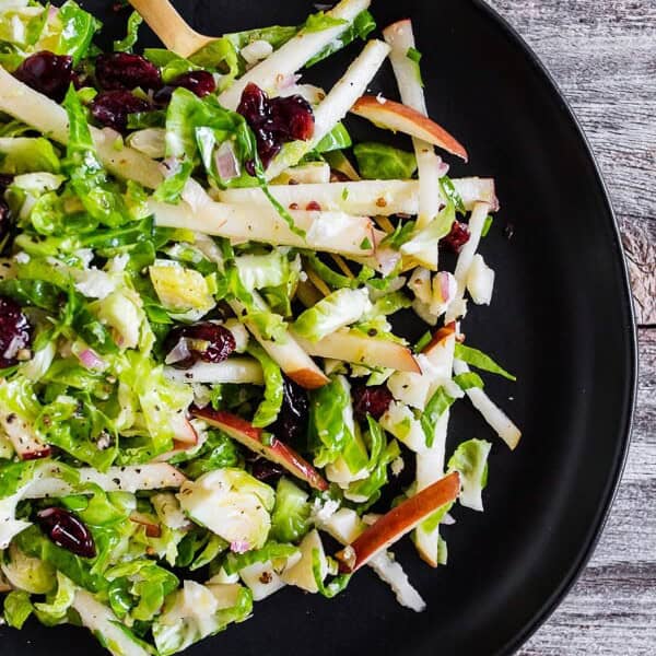 This tangy Brussels sprout apple slaw is a great addition to your fall menu. Crispy shaved Brussels sprout combined with dried cranberries, and apples all tossed in a homemade shallot whole grain mustard vinaigrette. You'll love this simple side dish!
