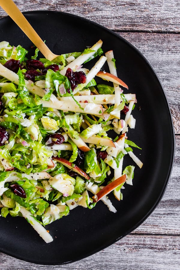 Tangy Brussels Sprout Apple Slaw on a black plate.