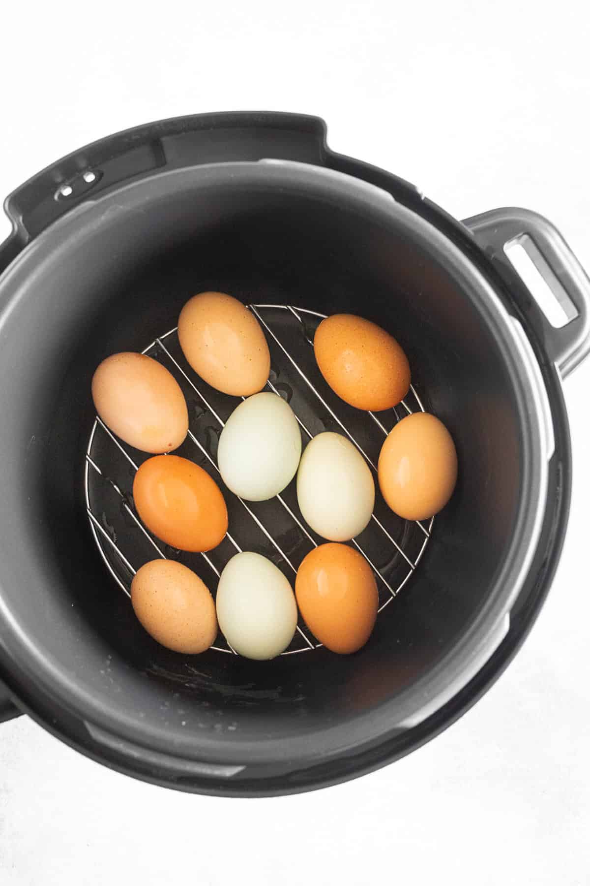 Eggs sitting inside a pressure cooker. 