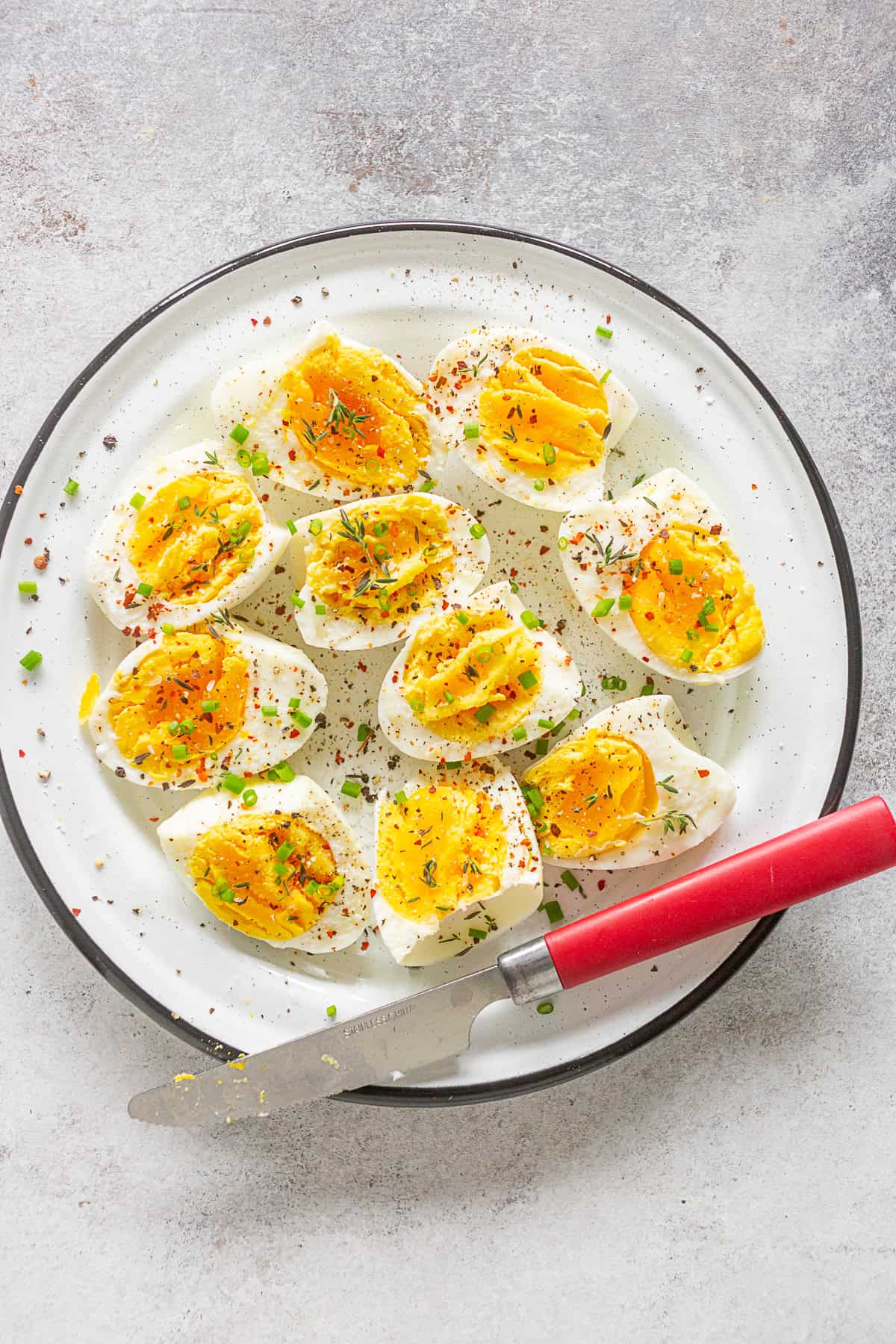 Instant Pot Hard Boiled Eggs on a plate sprinkled with fresh herbs and salt. 