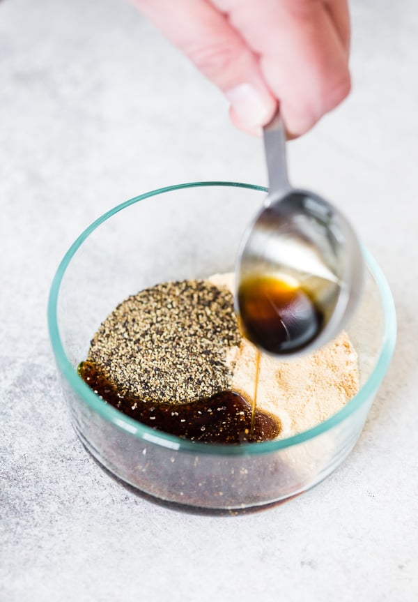 Pouring maple syrup into a bowl with spices.