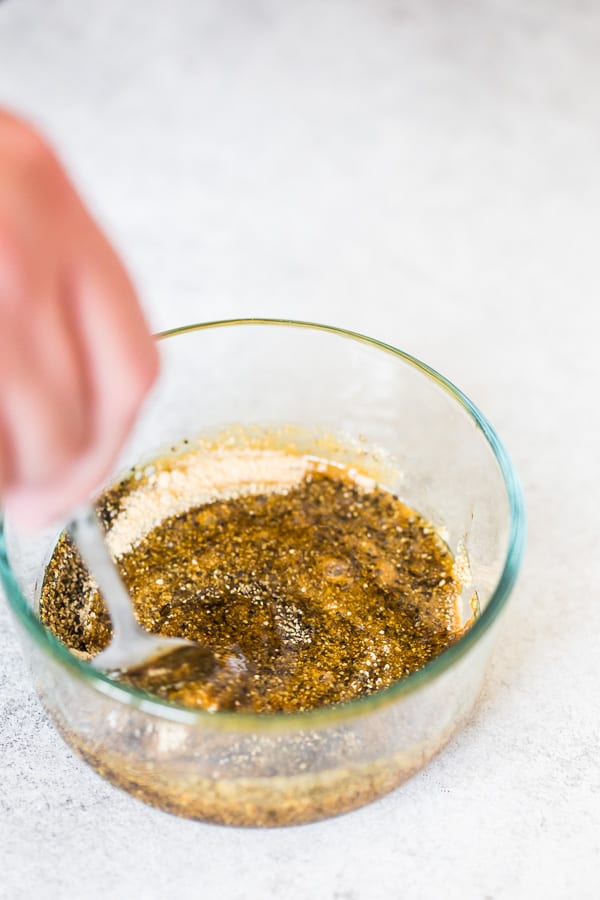 Mixing together spices in a bowl.