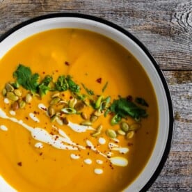 This spicy Thai pumpkin soup is ready in just 30 minutes and is packed full of flavor. It's super creamy and made with coconut milk, curry paste and tons of other Thai inspired flavors. Serve with all the toppings and devour! 