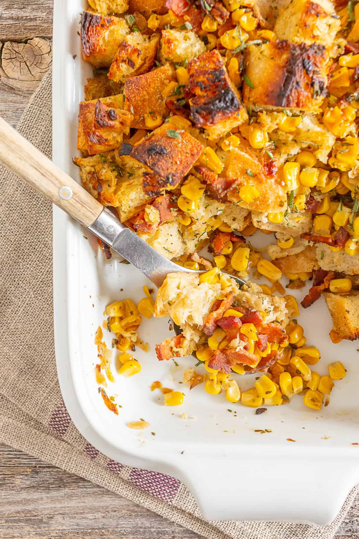 Bacon Corn Sourdough Stuffing scooped out to show the bacon and corn in the stuffing. 