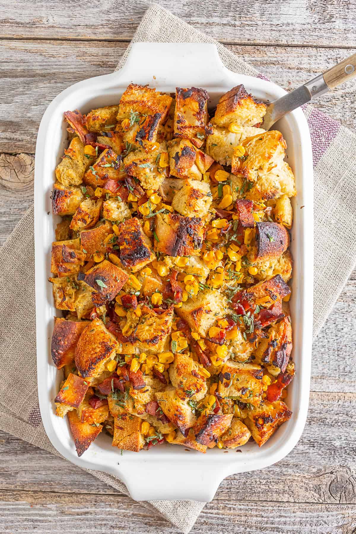 Bacon Corn Sourdough Stuffing in a white casserole dish. 