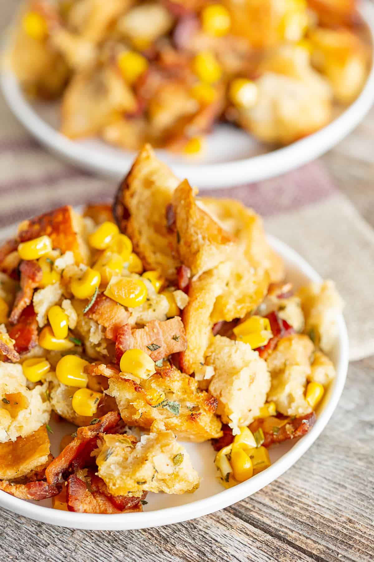 Bacon Corn Sourdough Stuffing scooped out onto a white plate. 