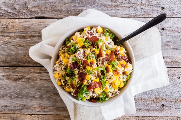 Creamy Bacon Jalapeno Corn Dip in a bowl with a spoon.