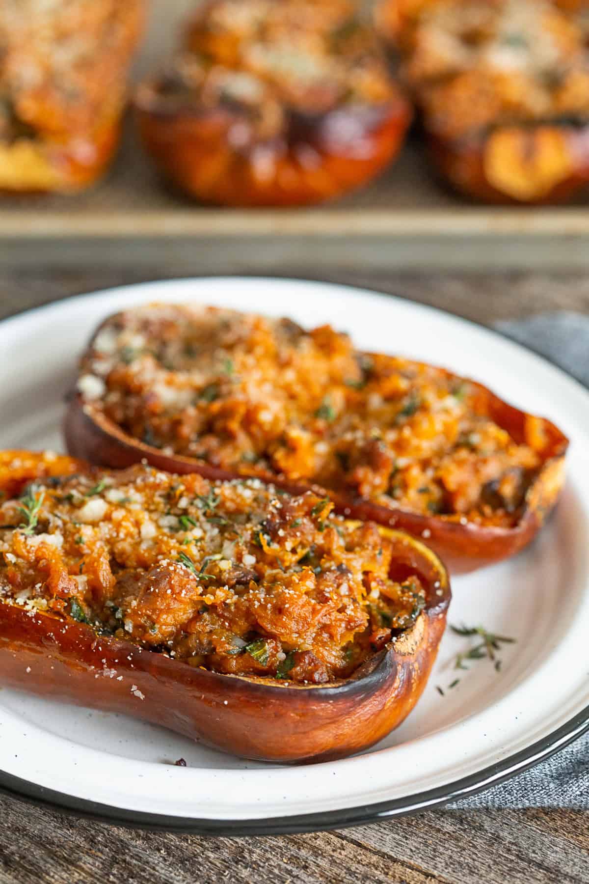 stuffed honeynut squash on served on a white ceramic plate.