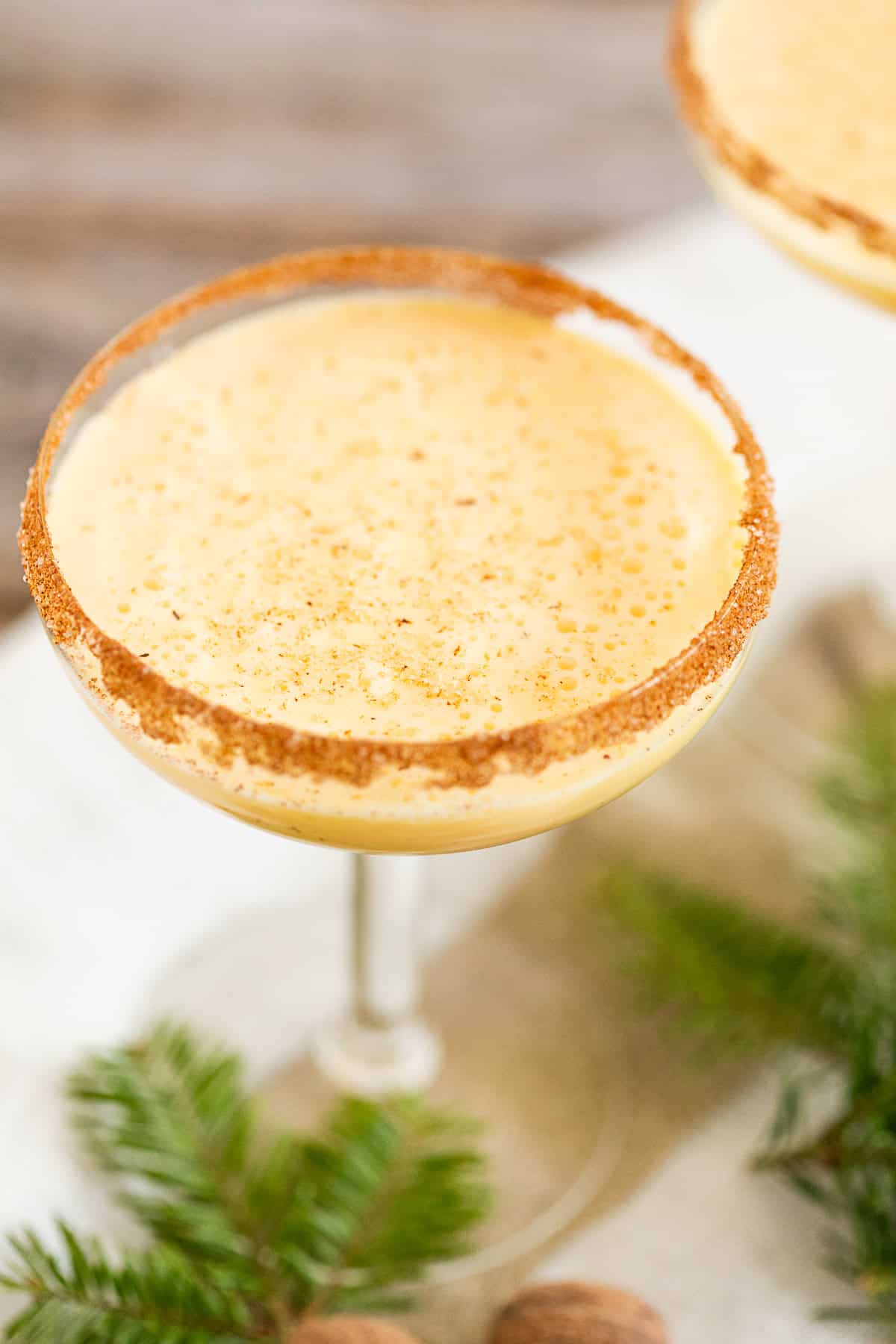 Eggnog martini with a cinnamon sugar rim and topped with nutmeg