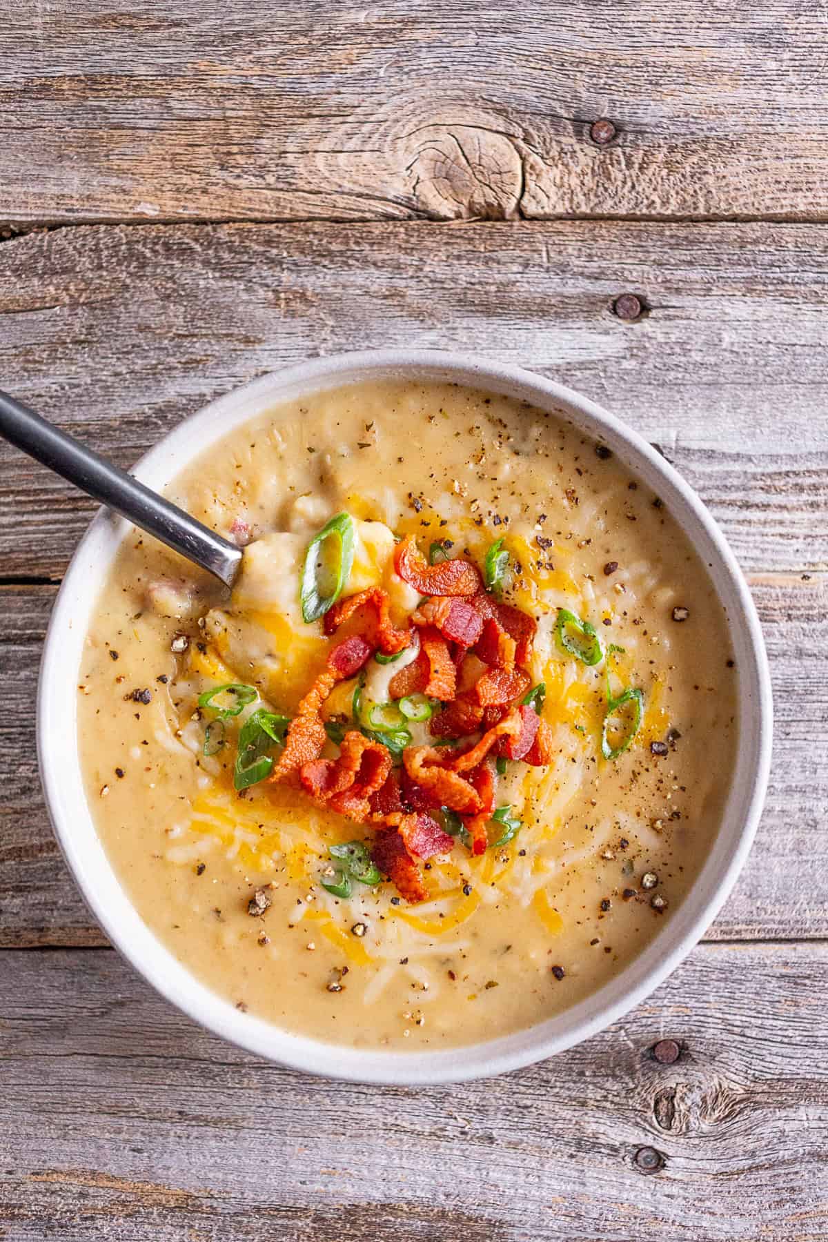 Loaded Baked Potato Soup topped with bacon, green onions, and cheese.
