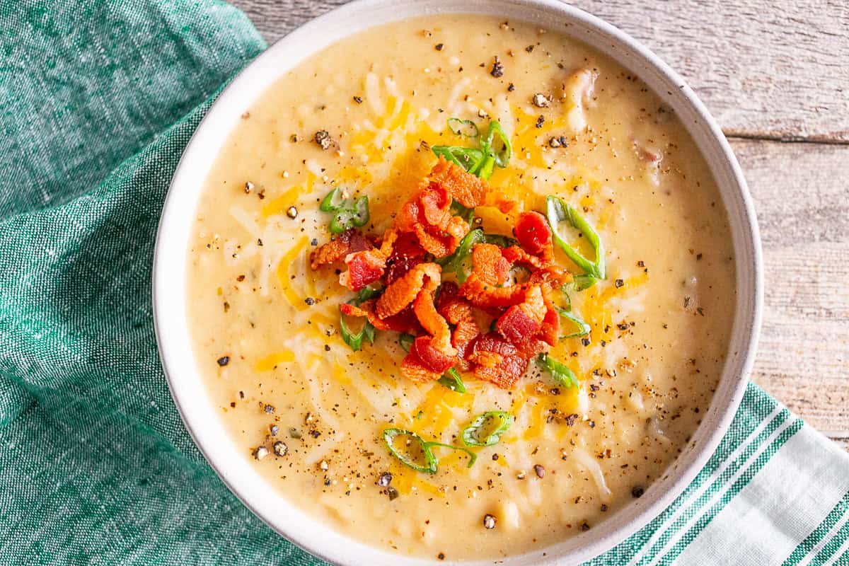 Loaded Baked Potato Soup in a ceramic bowl topped with toppings.