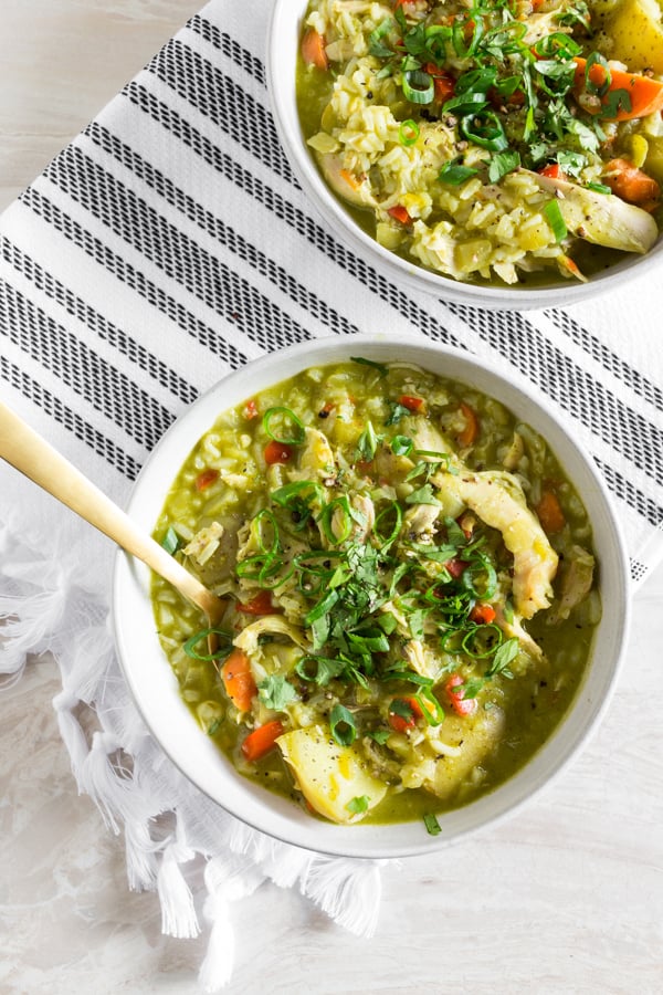 Peruvian Chicken Soup (Aguadito de Pollo) in a white bowl with a spoon.