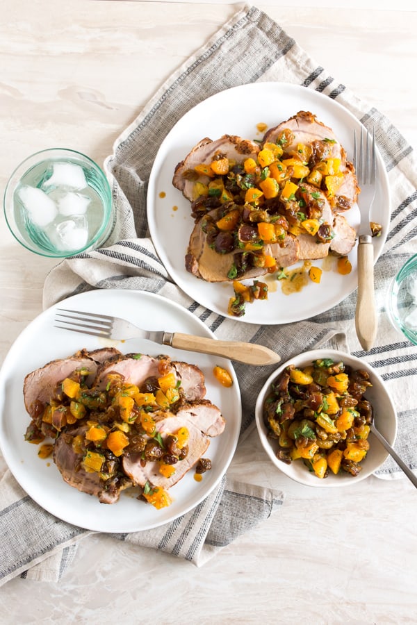This roasted pork loin with dried fruit compote is an easy and flavorful dinner recipe that your whole family will love. Roast Pork Loin with Dried Fruit Compote on 2 white plates.