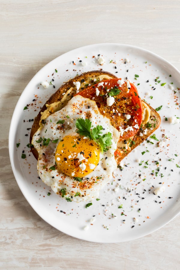 Shakshuka Hummus Toast on a white plate.