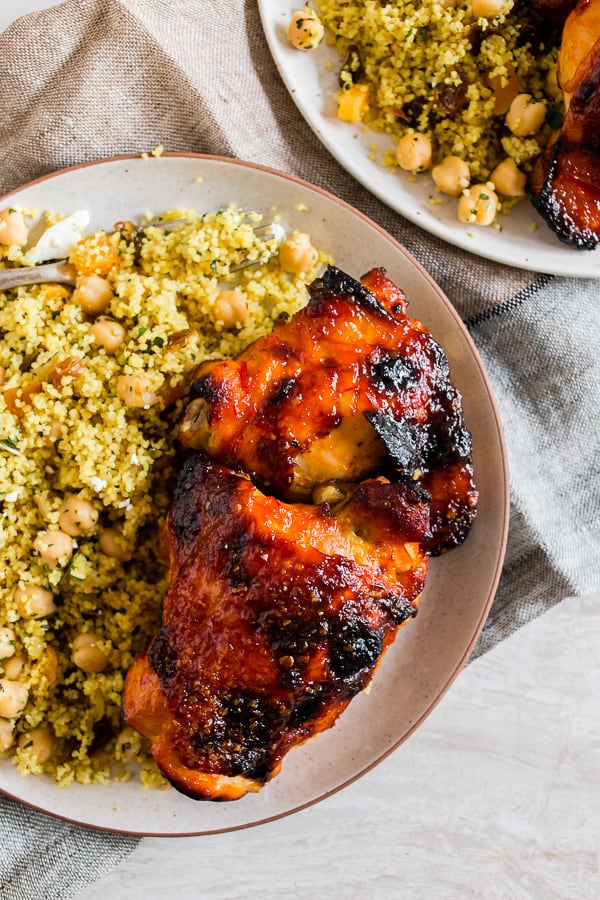 Harissa Chicken Thighs on a plate with couscous. 