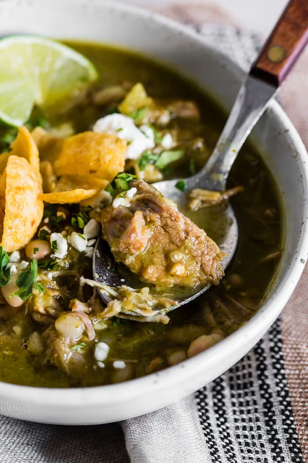 Instant Pot Pork Chili Verde in a bowl with pork on a spoon.