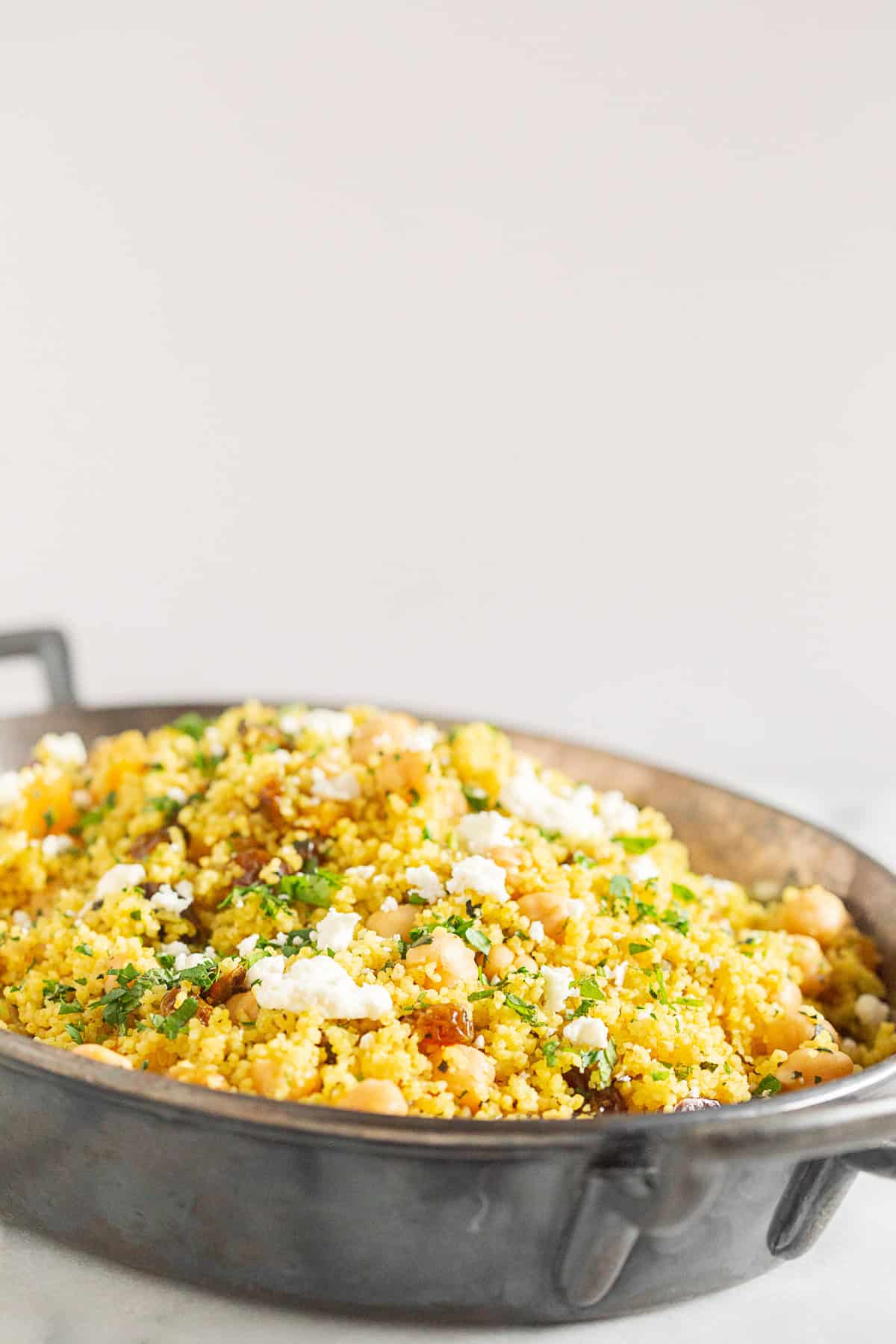 Moroccan Couscous topped with fresh herbs and feta cheese. 