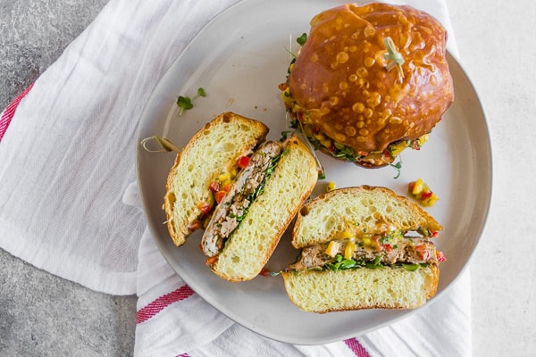 Chipotle Chicken Burgers Topped with Mango Salsa cut in half. 