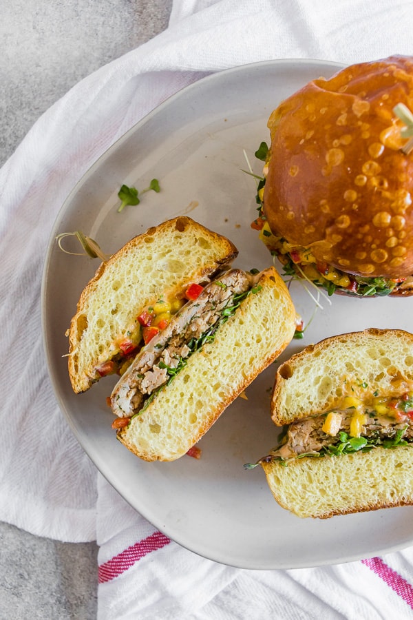Chipotle Chicken Burgers Topped with Mango Salsa cut in half to show the burger. 
