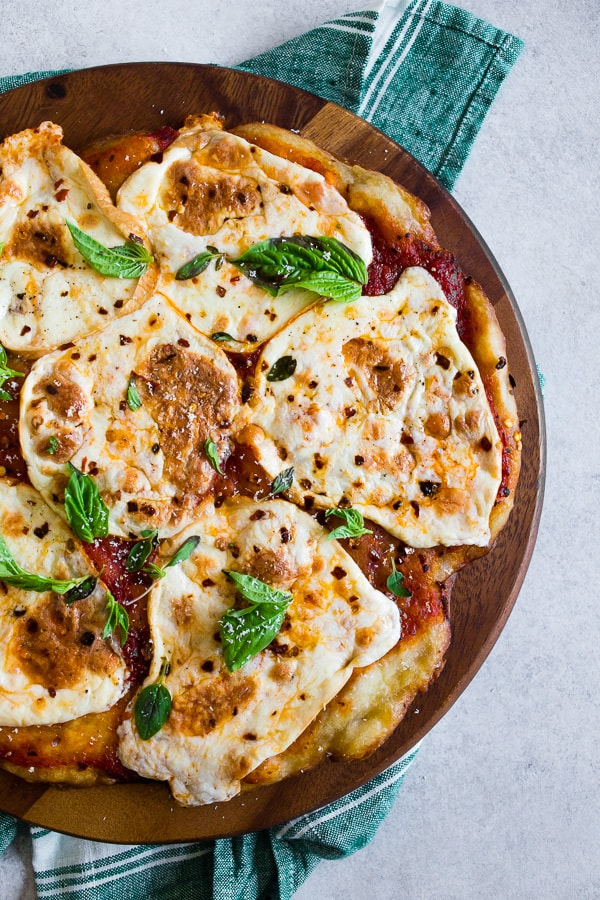 This smoked mozzarella pizza is topped with a light layer of marinara sauce, freshly smoked mozzarella cheese, fresh herbs and a sprinkle of grated Parmesan. It's packed full of flavor and cooks in just about 20 minutes. 